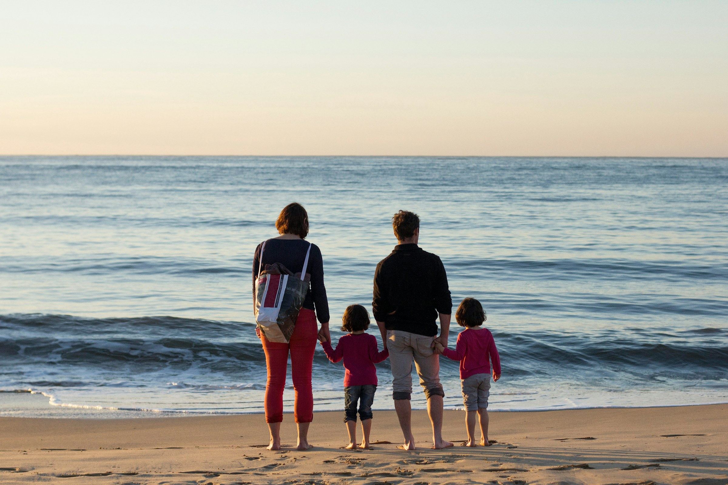 A family holding hands at the water's edge
